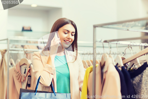 Image of happy young woman choosing clothes in mall