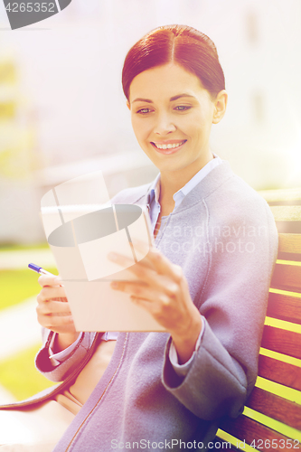 Image of businesswoman reading notes in notepad outdoors