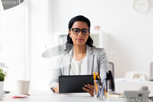 Image of smiling businesswoman with tablet pc at office