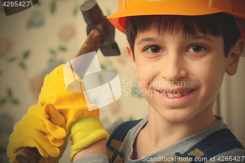 Image of Boy in the image of a builder with a hammer in his hands