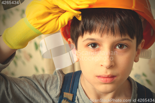 Image of Boy wearing a protective helmet and gloves