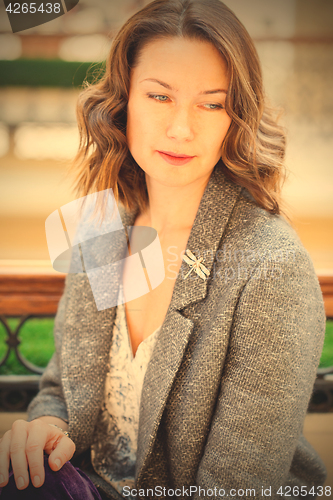 Image of woman in gray jacket with dragonfly brooch