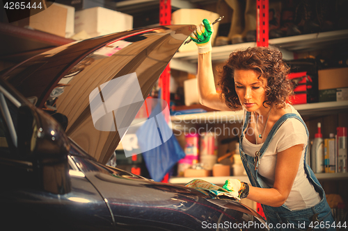 Image of beautiful woman in the jumpsuit of an auto mechanic
