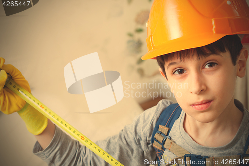 Image of boy in a protective helmet with a measuring tape