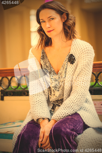 Image of woman in gray knitted coat with black brooch