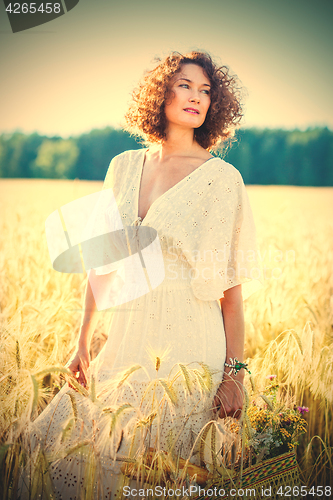 Image of Beautiful woman dressed in a white dress among the ears in the f