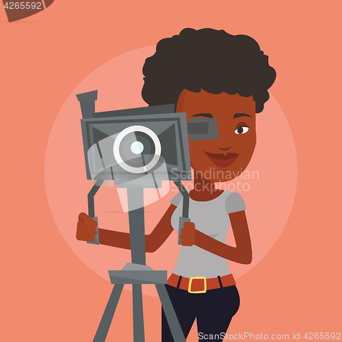 Image of Cameraman with movie camera on tripod.