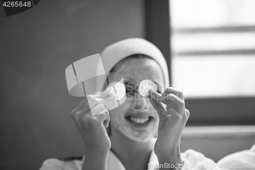 Image of woman is getting facial clay mask at spa