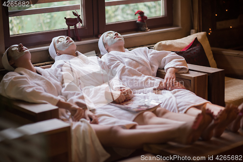 Image of women is getting facial clay mask at spa