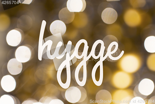 Image of word hygge over blurred golden lights background