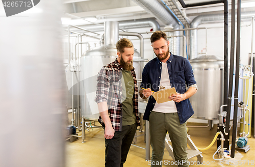 Image of men with clipboard at craft brewery or beer plant