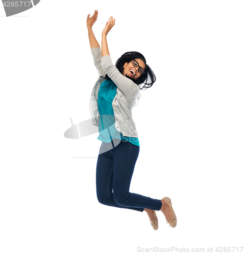 Image of smiling young indian woman jumping in air