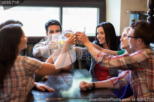 Image of happy friends drinking beer at bar or pub
