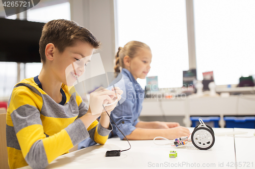 Image of happy children building robots at robotics school