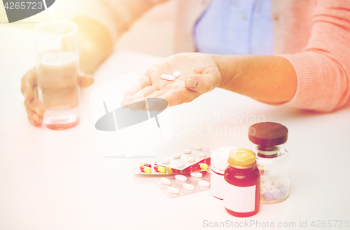 Image of close up of senior woman with pills and water 