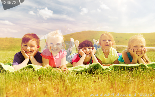 Image of group of kids lying on blanket or cover outdoors