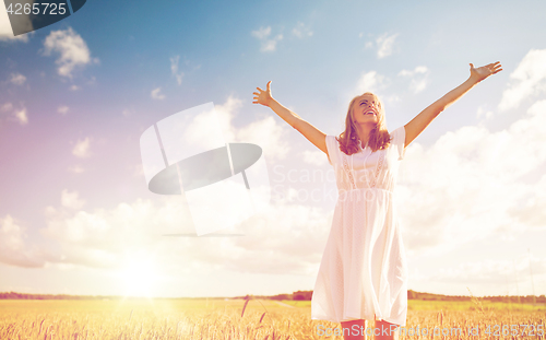 Image of smiling young woman in white dress on cereal field