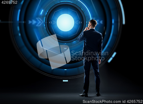Image of businessman in suit looking at virtual projection