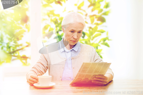Image of senior woman with coffee reading newspaper