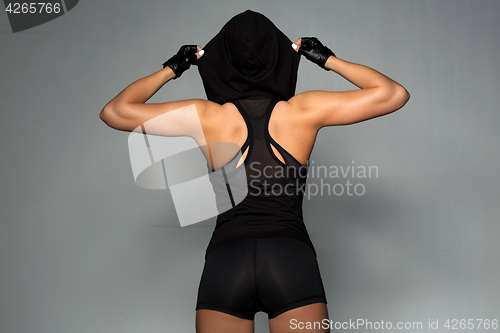 Image of young woman in black sportswear posing
