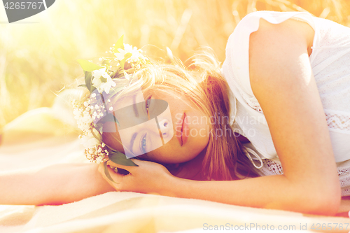 Image of happy woman in wreath of flowers on cereal field