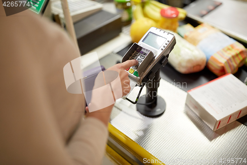 Image of woman entering pin code at store cash register