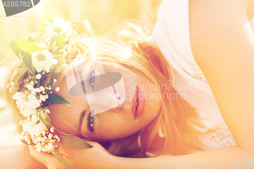 Image of happy woman in wreath of flowers on cereal field