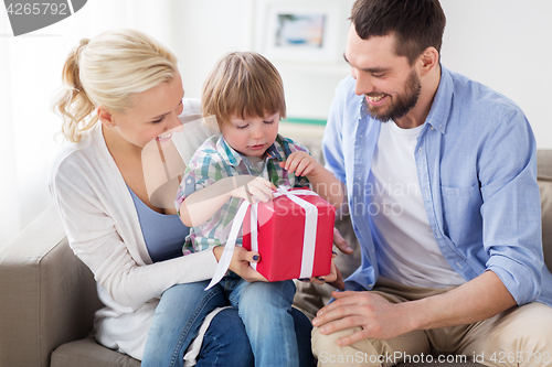 Image of happy family with birthday gift at home