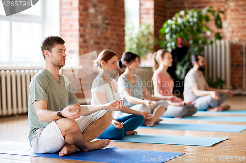 Image of group of people making yoga exercises at studio