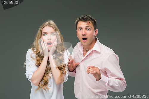 Image of Portrait of a young couple standing against gray background