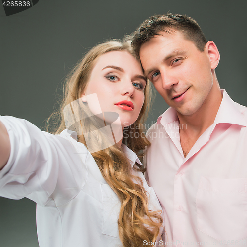 Image of Portrait of a young couple standing against gray background