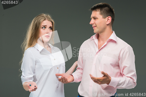 Image of Portrait of a young couple standing against gray background