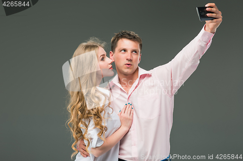 Image of Portrait of a young couple standing against gray background