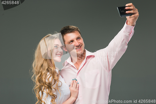 Image of Portrait of a young couple standing against gray background