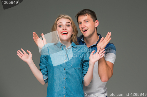 Image of Portrait of a young couple standing against gray background