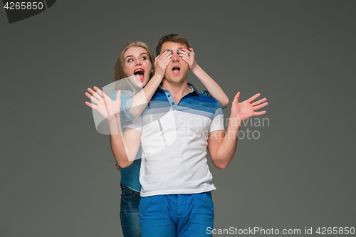 Image of Portrait of a young couple standing against gray background