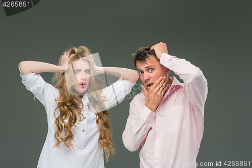 Image of Portrait of a young couple standing against gray background