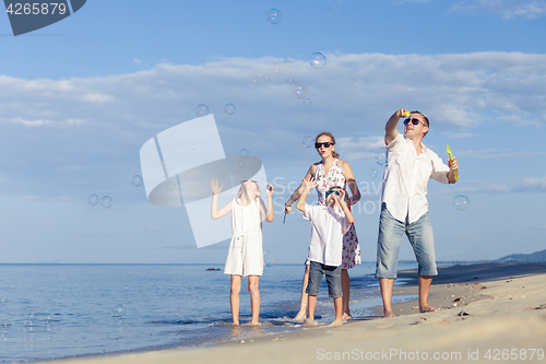 Image of Happy family walking on the beach at the day time.