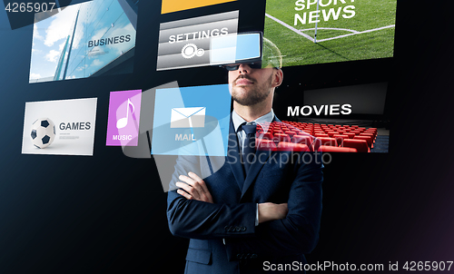 Image of businessman in virtual reality headset over black