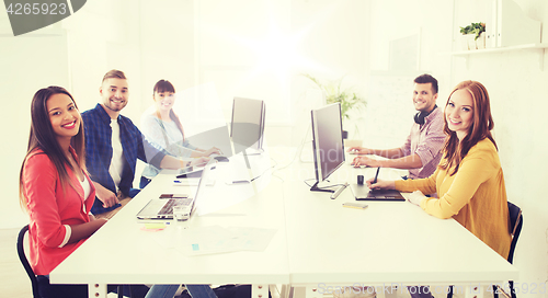 Image of creative team with computers, blueprint at office