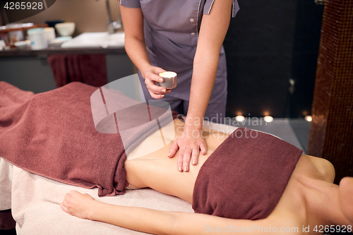 Image of woman lying and having massage with hot oil at spa