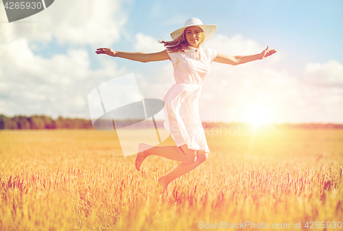 Image of happy young woman jumping on cereal field