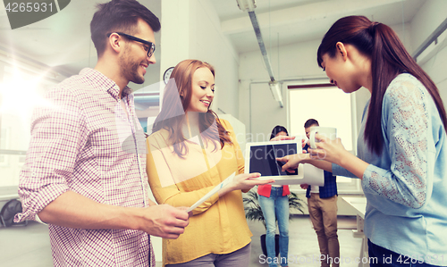 Image of creative team with tablet pc talking at office