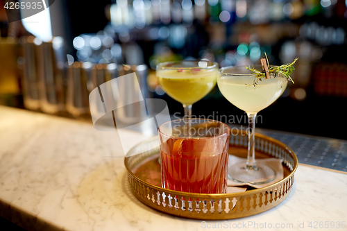 Image of tray with glasses of cocktails at bar
