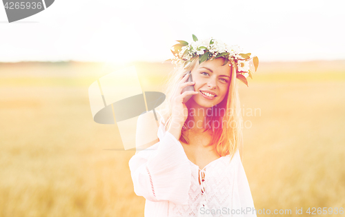 Image of happy young woman calling on smartphone at country