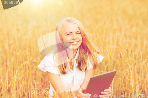 Image of happy young woman with tablet pc on cereal field