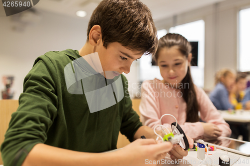 Image of happy children building robots at robotics school