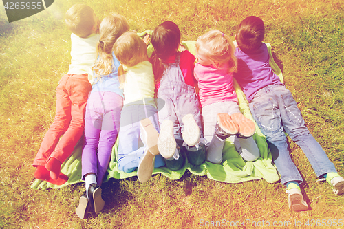 Image of group of kids lying on blanket or cover outdoors