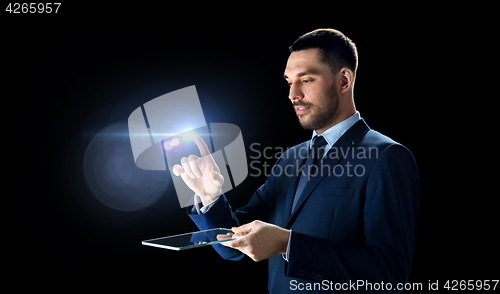 Image of businessman in suit with transparent tablet pc