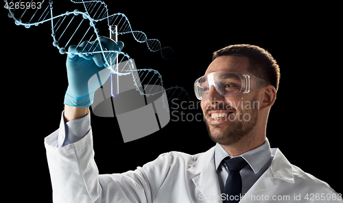 Image of smiling scientist in safety glasses with test tube